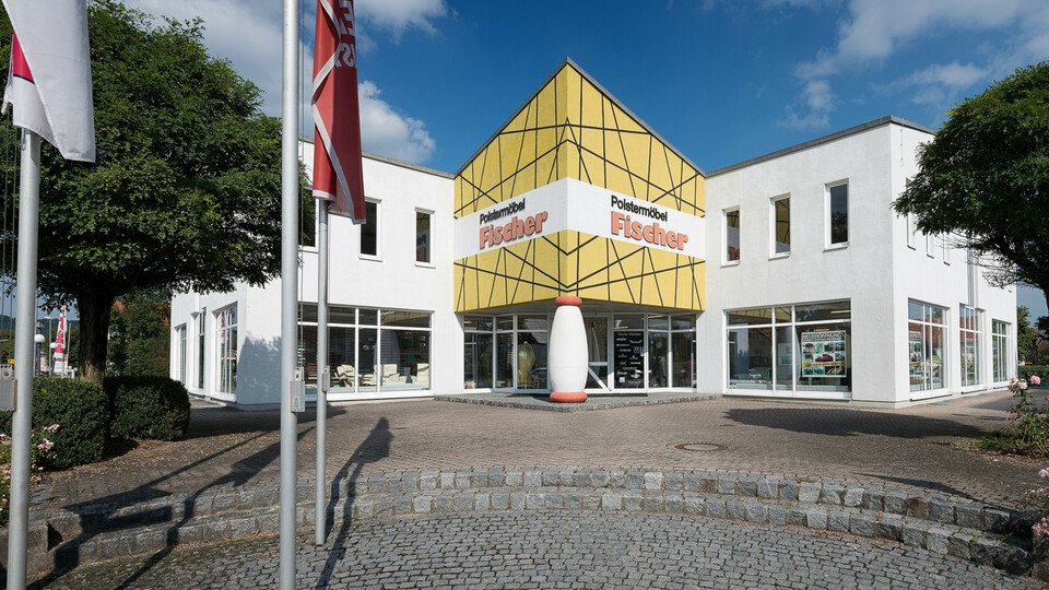 Modernes Mehrzweckgebäude mit gelber Pyramide.