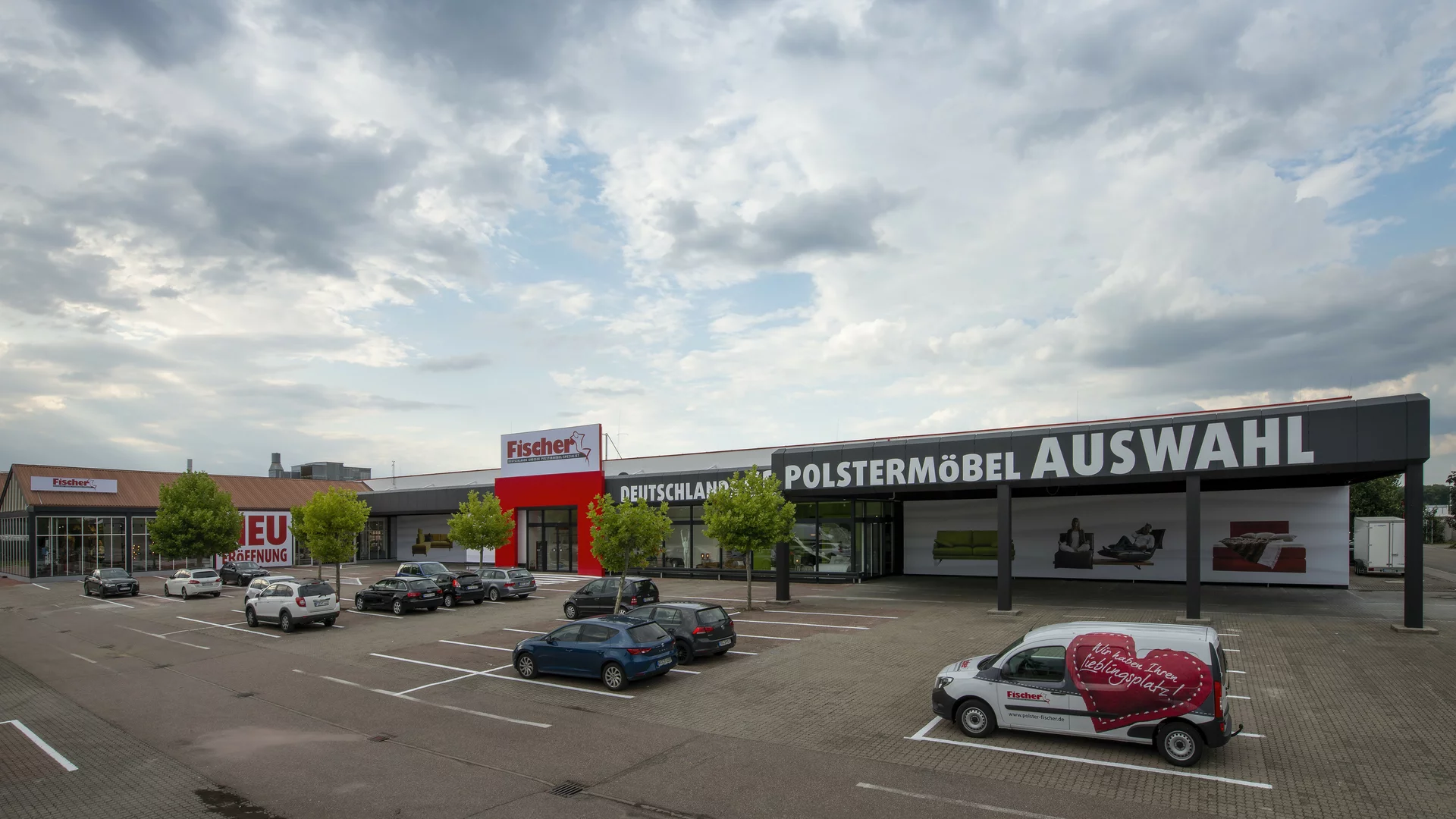 Großes Möbelgeschäft mit Parkplatz und Produktangebote.