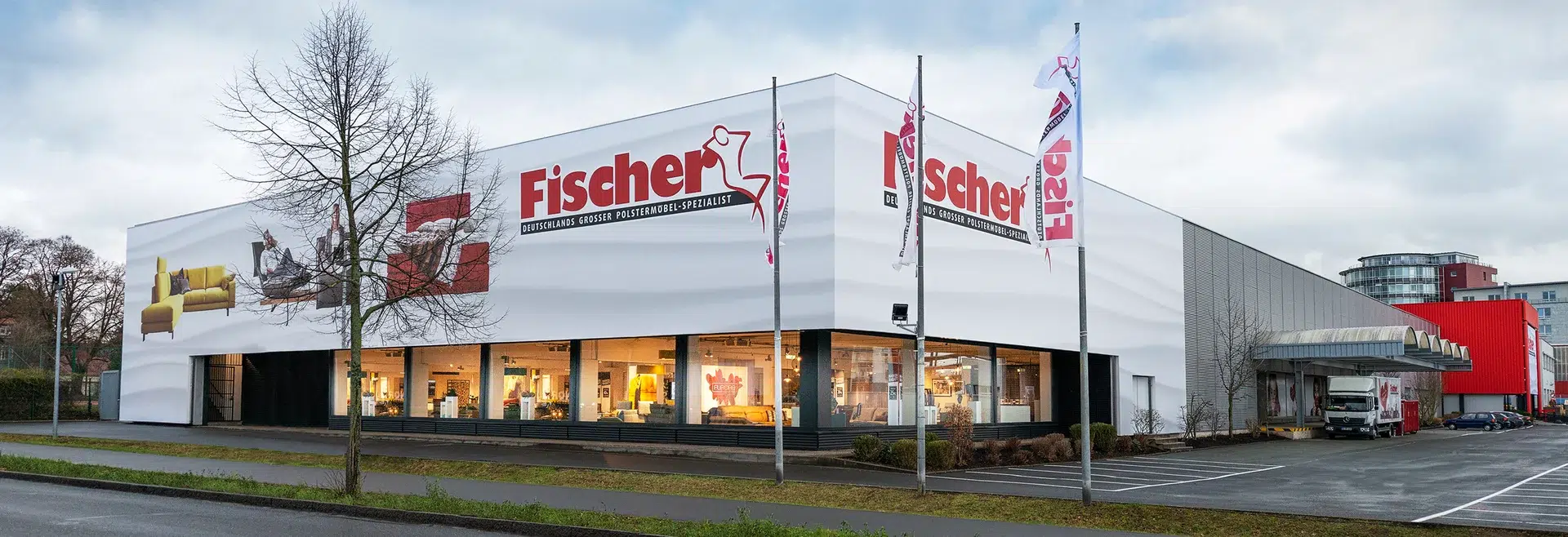 Großes Möbelhaus Fischer mit Fahnen und Werbetafeln.