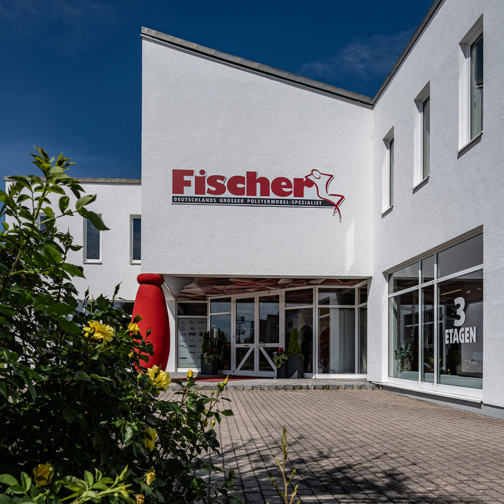 Mehrstöckiges Möbelhaus "Fischer" mit Schaufenstern und Skulptur