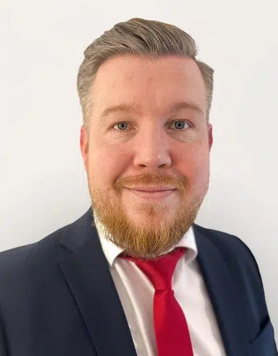 Mann mit Hemd, Krawatte und Anzug in Porträt.