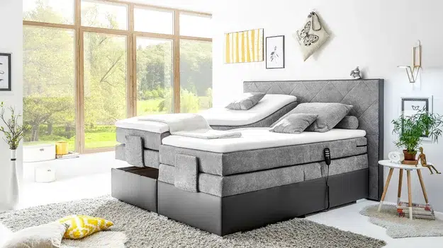 Gemütliches Boxspringbett mit Aussicht auf Natur.