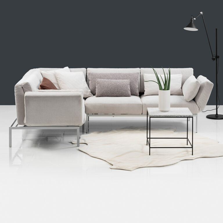Modernes, gemütliches Wohnzimmer mit Sofa, Kissen und Tischdekor.