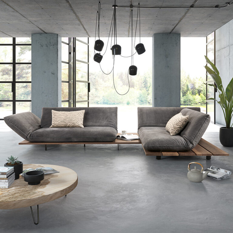 Modernes, urbanes Wohnzimmer mit Betonwänden und Fensterfront.