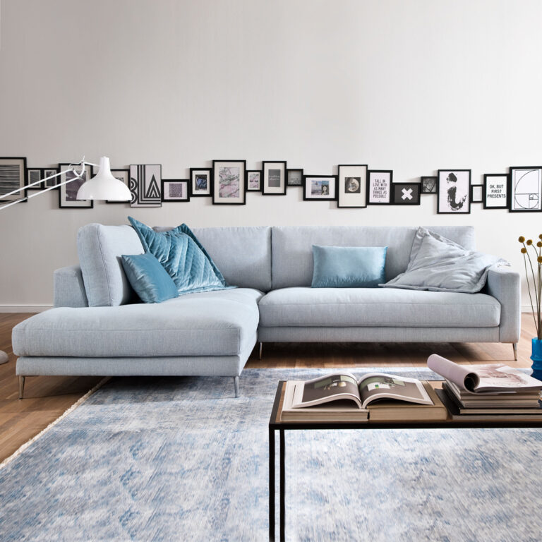 Moderne Wohnzimmereinrichtung mit Couch, Bildern und Dekoration.