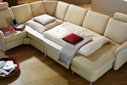 Gemütliche Ledercouch mit Kissen und Tisch.