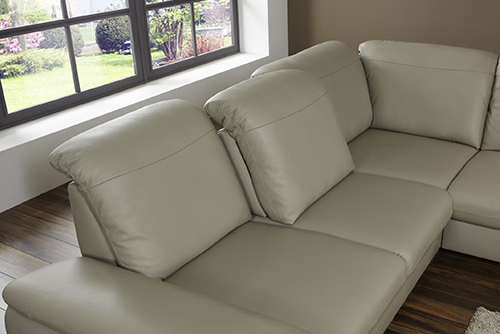 Helles Ledersofa mit Ausblick auf Garten.