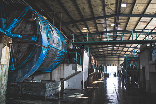 Großer blauer Schienentransport in verlassenem Industrieraum.