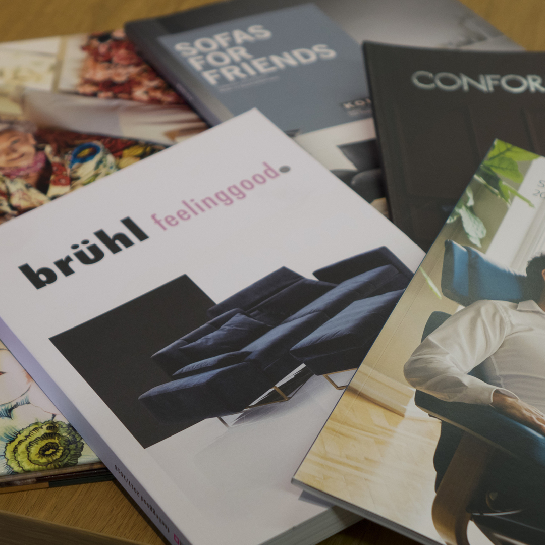 Verschiedene Bücher und Zeitschriften auf einem Holztisch.
