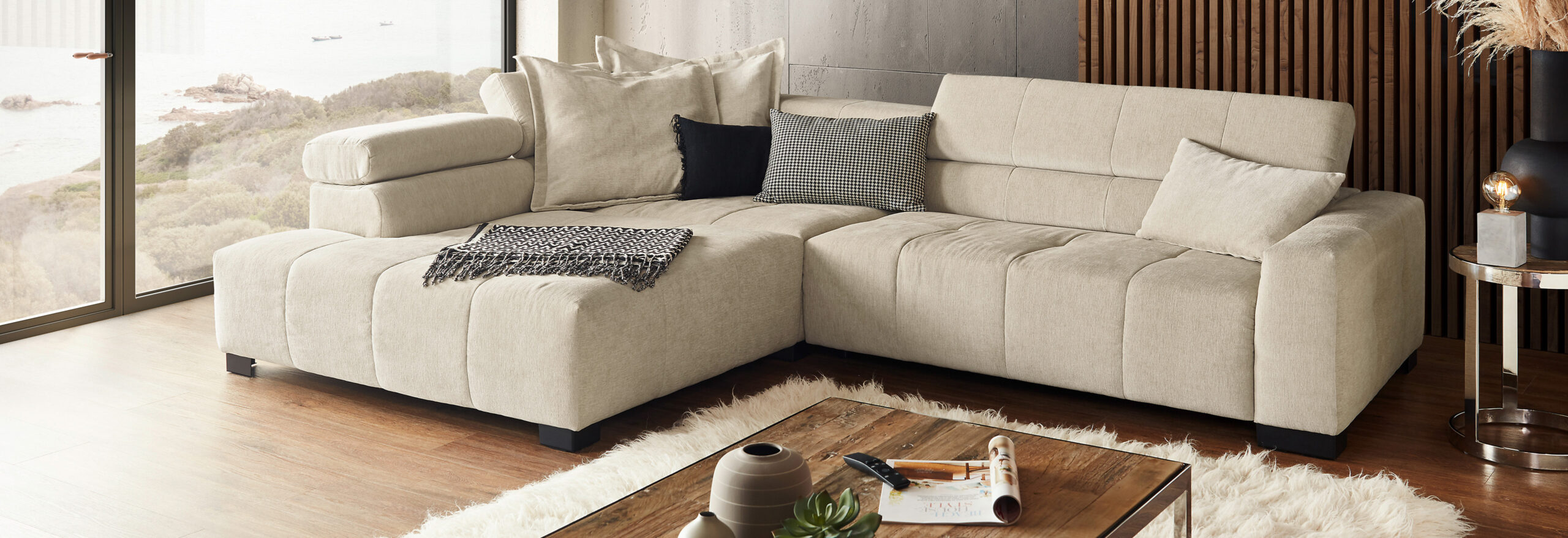 Gemütliches Wohnzimmer mit Couch, Kissen und Dekorationen.