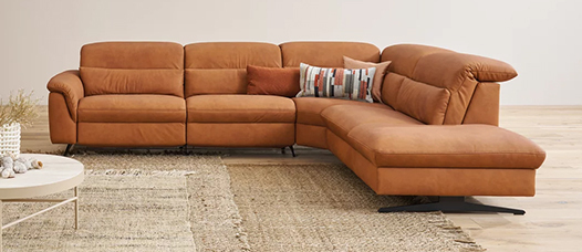 Gemütliches Ledersofa mit bunten Kissen.