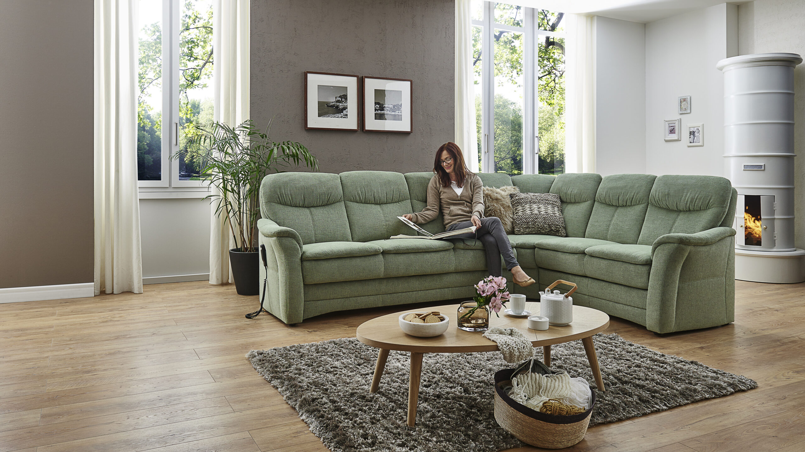Gemütliches Wohnzimmer mit Sofa und lesender Person.
