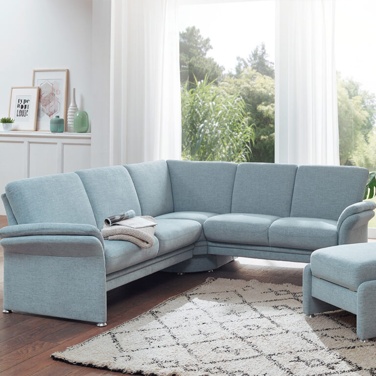 Modernes Wohnzimmer mit grauer Couch und Blick in die Natur.