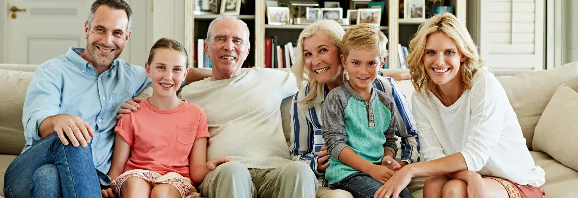 Fröhliche Familie sitzt zusammen auf der Couch.