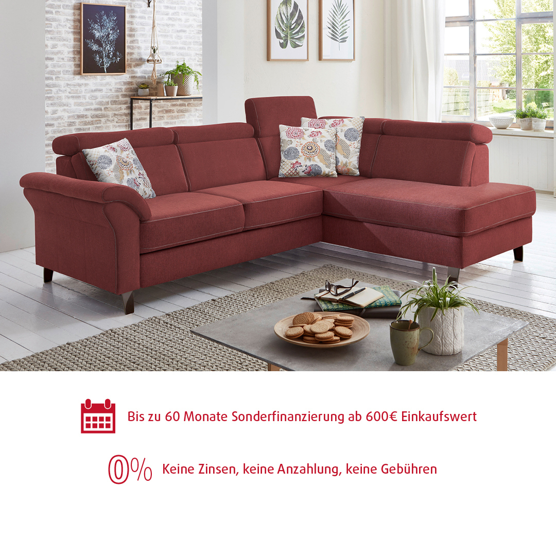 Gemütliches Ecksofa in Rot inmitten eines hellen Wohnzimmers.