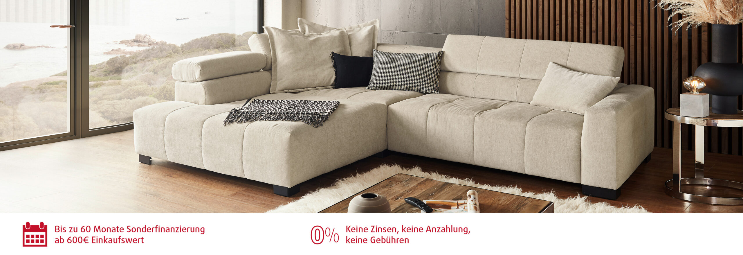 Gemütliches Wohnzimmer mit Ecksofa und Blick auf Landschaft.