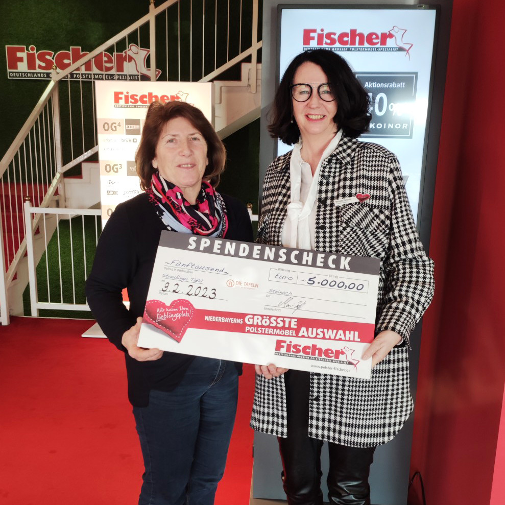 Zwei Frauen halten einen großen Spendencheck für die Firma Fischer.