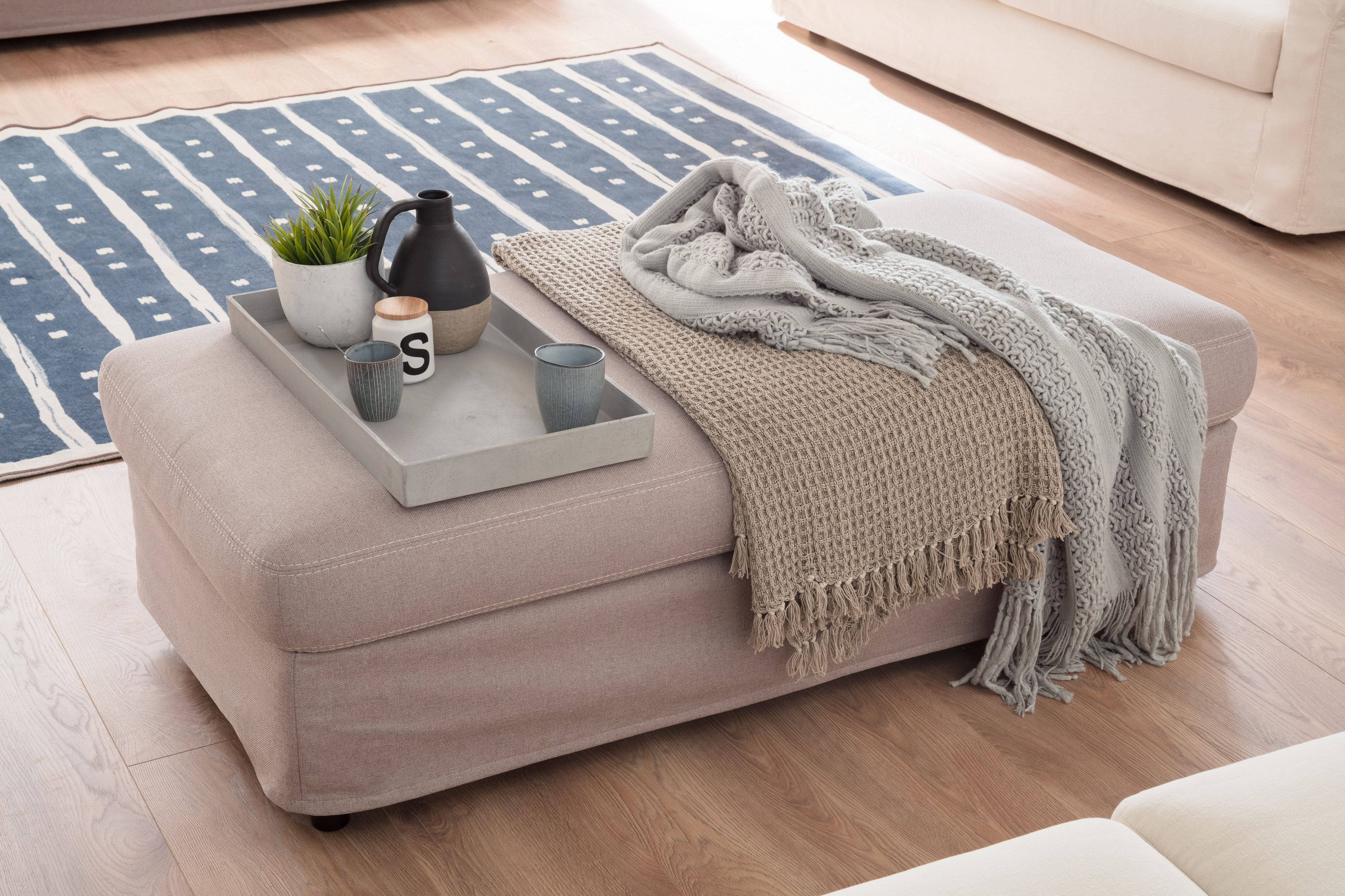 Gemütliches Wohnzimmer mit Decke und Tisch.