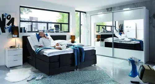 Modernes, geräumiges Schlafzimmer mit großen Fenstern.
