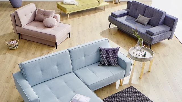Modernes Wohnzimmer mit Couch, Sessel und Dekorationen.