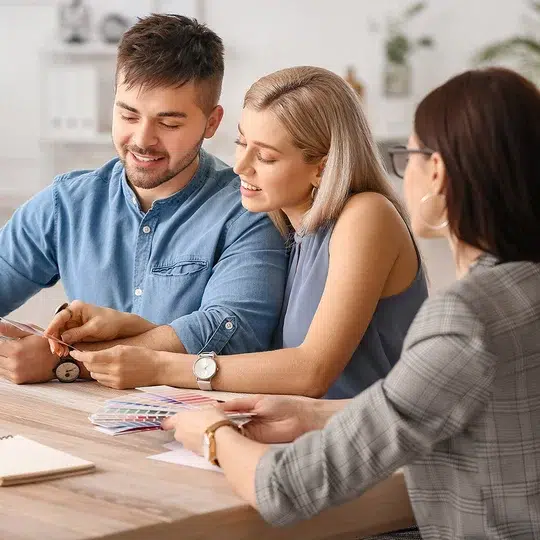 Drei Personen besprechen und arbeiten zusammen an einem Tisch.