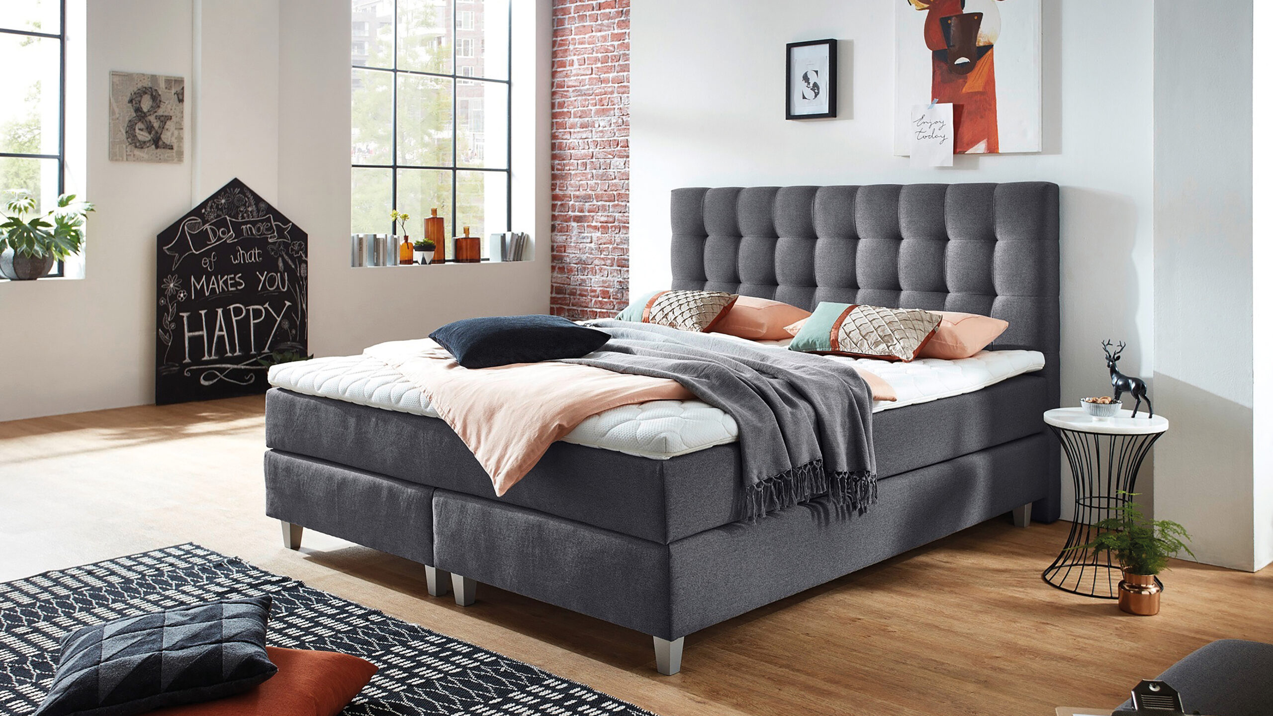 Gemütliches Schlafzimmer mit Boxspringbett und dekorativen Elementen.
