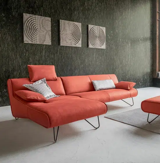 Rote Ledercouch vor strukturierter Wand.