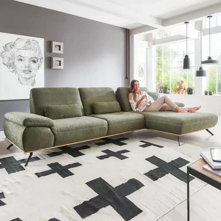 Gemütliches Wohnzimmer mit Ecksofa und Fensterfront.