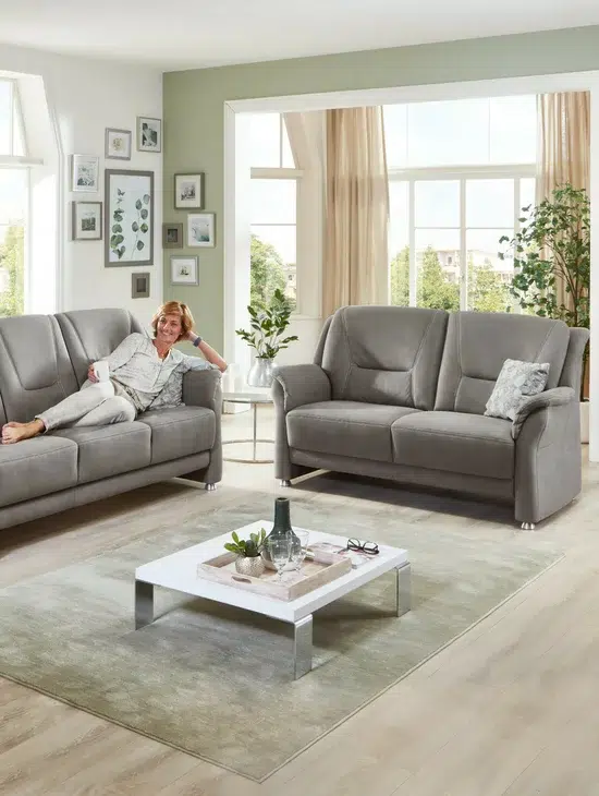 Gemütliches Wohnzimmer mit grauer Couch und Dekoration.