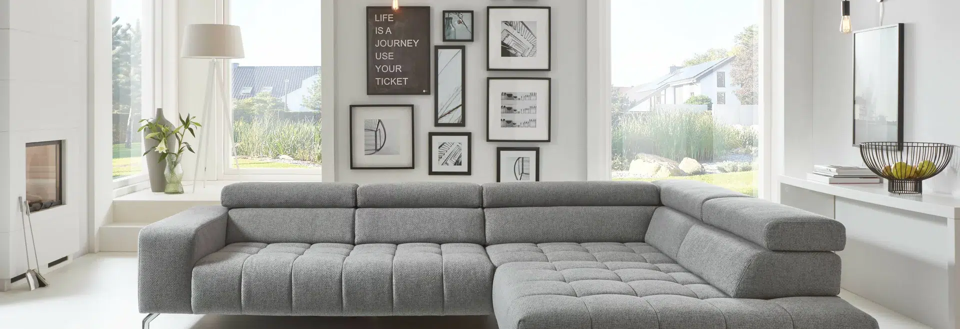 Modernes, gemütliches Wohnzimmer mit grauem Sofa und Wanddekor.