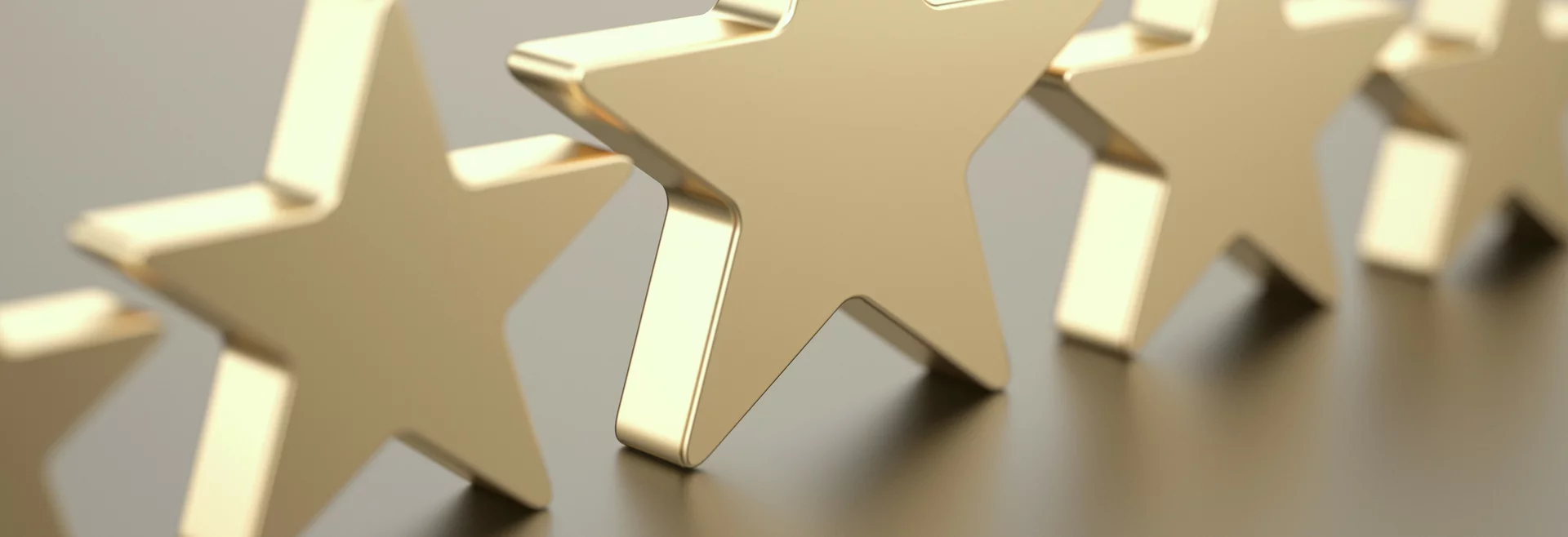 Glänzende, goldene Sterne auf grauem Hintergrund.