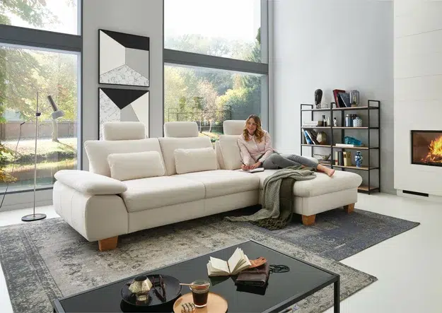 Gemütliches Wohnzimmer mit Frau auf Sofa.