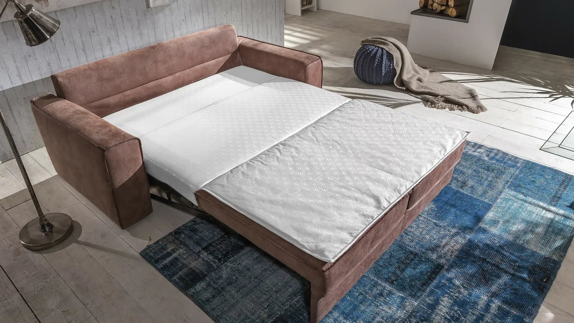 Gemütliches Schlafzimmer mit Samtsofa und Decke.
