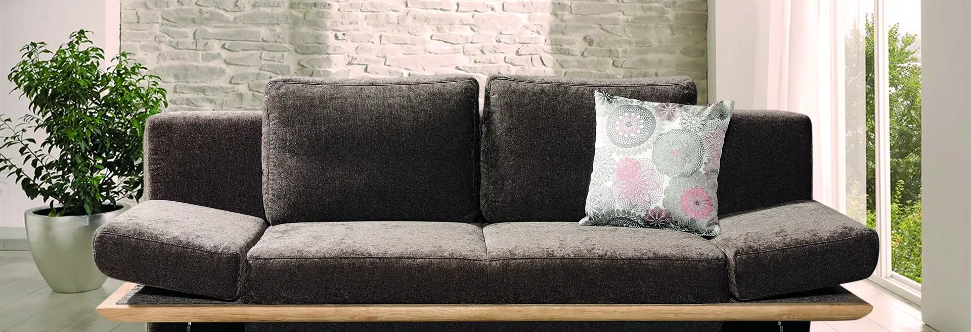 Gemütliche moderne Sitzecke mit Couch und Pflanze.