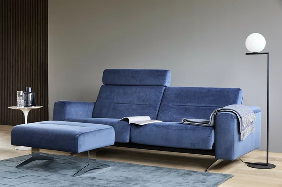 Blaues Ecksofa, Couchtisch und Stehlampe im modernen Wohnzimmer.