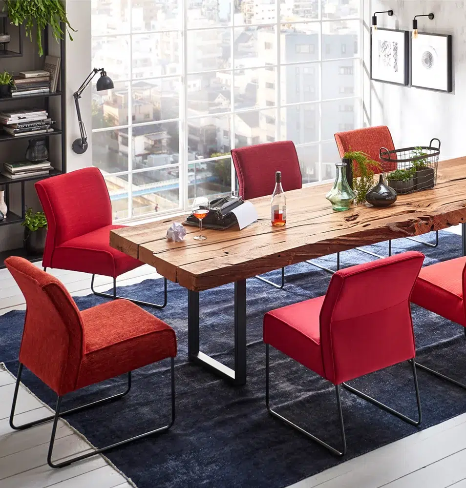 Modernes Esszimmer mit Holztisch und roten Stühlen.