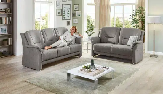 Gemütliches Wohnzimmer mit grauen Sofas und Dekorationen.