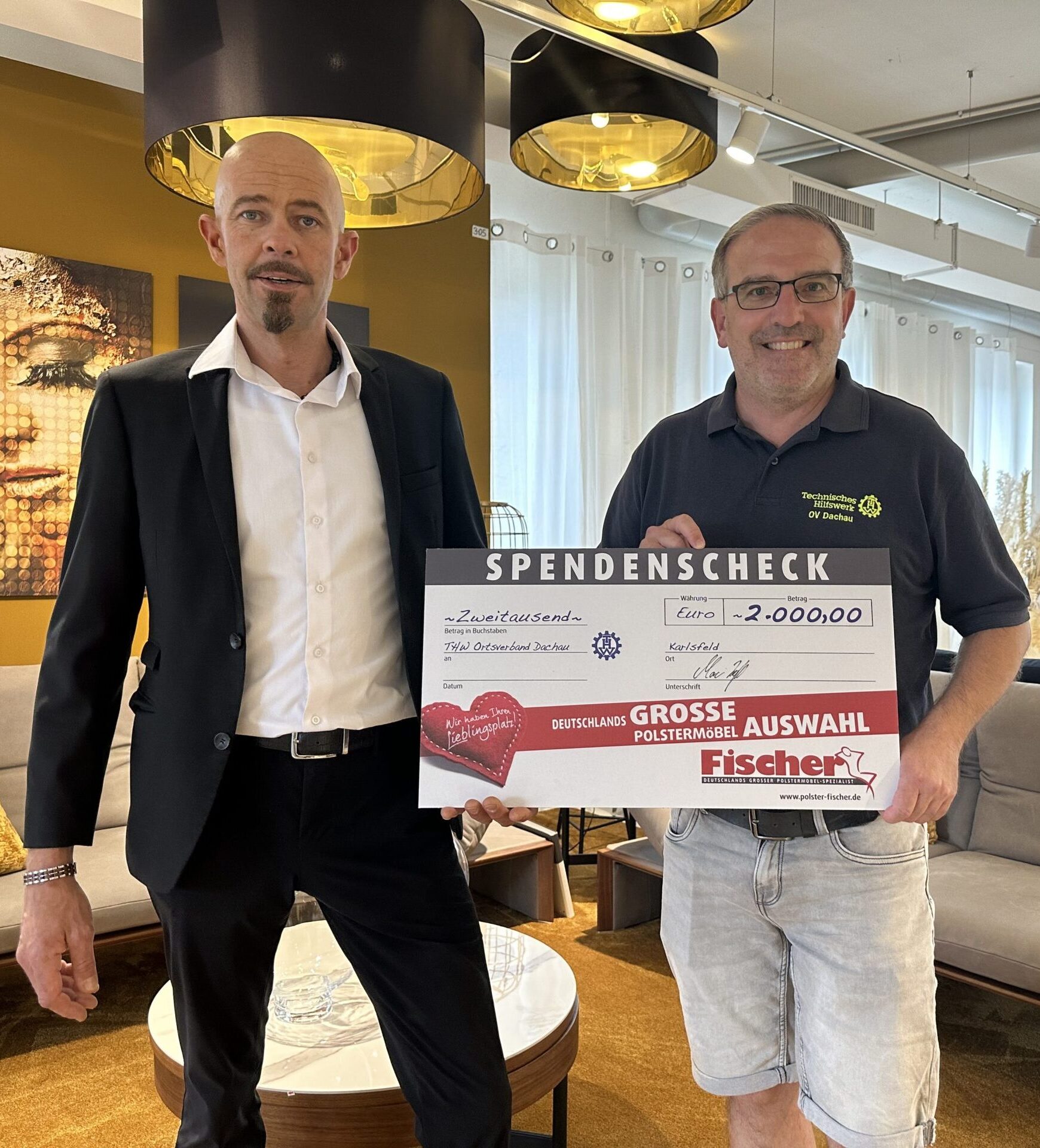 Zwei Männer präsentieren einen Spendencheck in Höhe von 2000 Euro.