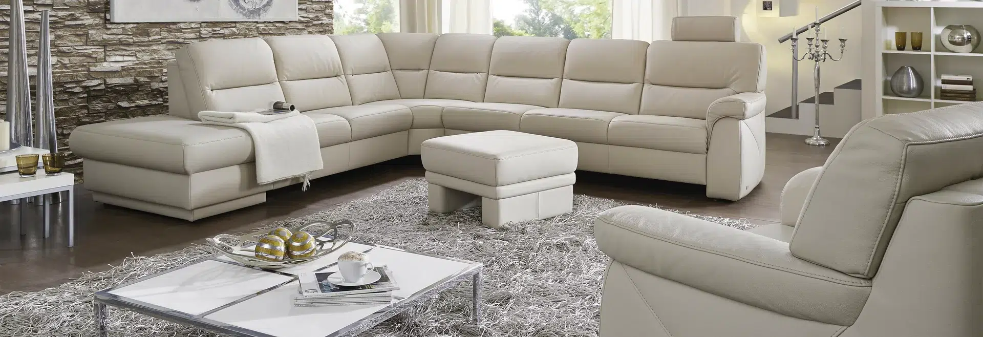 Luxuriöses Wohnzimmer mit beige Ecksofa und Beistelltisch.