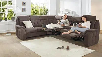 Zwei Menschen sitzen gemütlich auf einem Sofa.