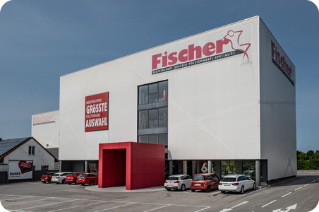 Moderne Polstermöbel Fischer Filiale in Steinach mit markanter weißer Fassade, rotem Eingang und großer Außenbeschriftung