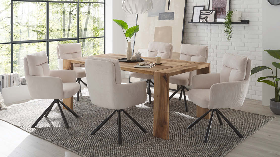 Essgruppe mit hellem Holz-Esstisch und sechs gepolsterten Stühlen in zarten Creme- und Beigetönen, modern inszeniert im Vanilla-Girl-Trend.