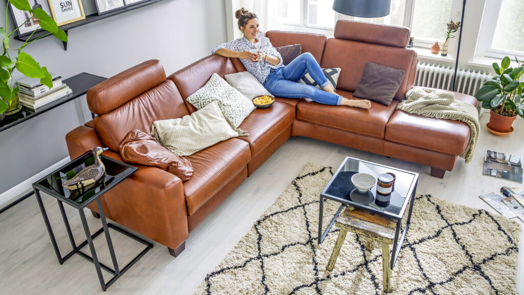 Modernes Ecksofa aus braunem Leder mit verstellbaren Kopfstützen in stilvollem Wohnzimmer – hochwertiges Ledersofa für entspanntes Wohnen bei Polstermöbel Fischer.