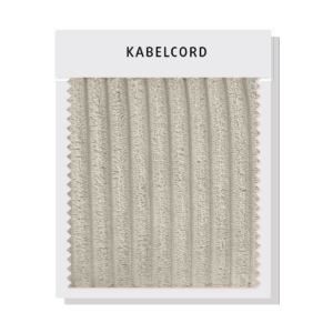 Detailaufnahme eines Sofas mit Kabelcord-Bezug, der durch breitere, stärker ausgeprägte Rippen eine besonders robuste Textur und ein charakteristisches, markantes Erscheinungsbild bietet.