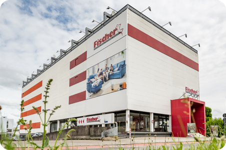 Großes, mehrstöckiges Gebäude der Polstermöbel-Fischer-Filiale in Fellbach mit Werbebannern und auffälliger roter Fassade.