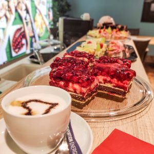 Cappuccino mit Herz und Himbeerschnitten auf einer Theke bei Polstermöbel Fischer – Verkaufsaktion mit Bewirtung