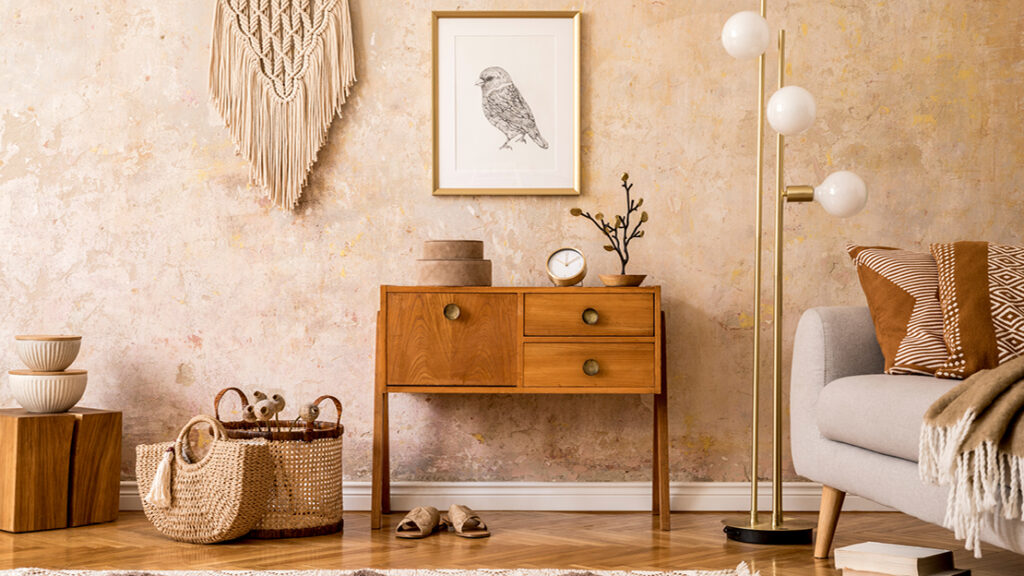 Wohnzimmer im modernen Boho-Stil mit Holzmöbeln, Wandmakramee und gemütlichem Sofa – Wohntrend bei Polstermöbel Fischer.