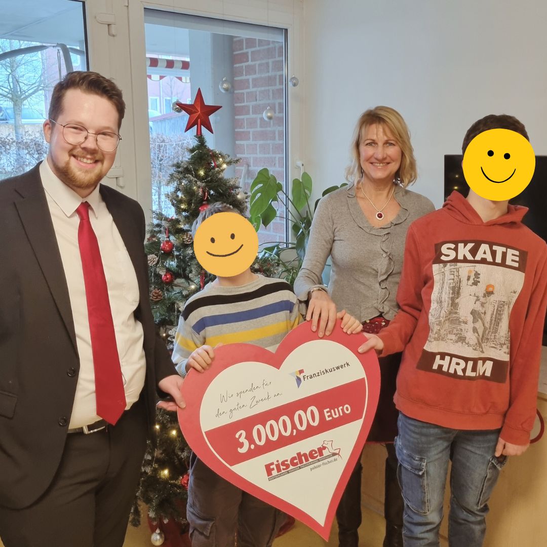 Mitarbeitende von Polsterm&ouml;bel Fischer &uuml;berreichen im Dezember eine Spende &uuml;ber 3.000 Euro an das Franziskuswerk, weihnachtliche Atmosph&auml;re mit Tannenbaum