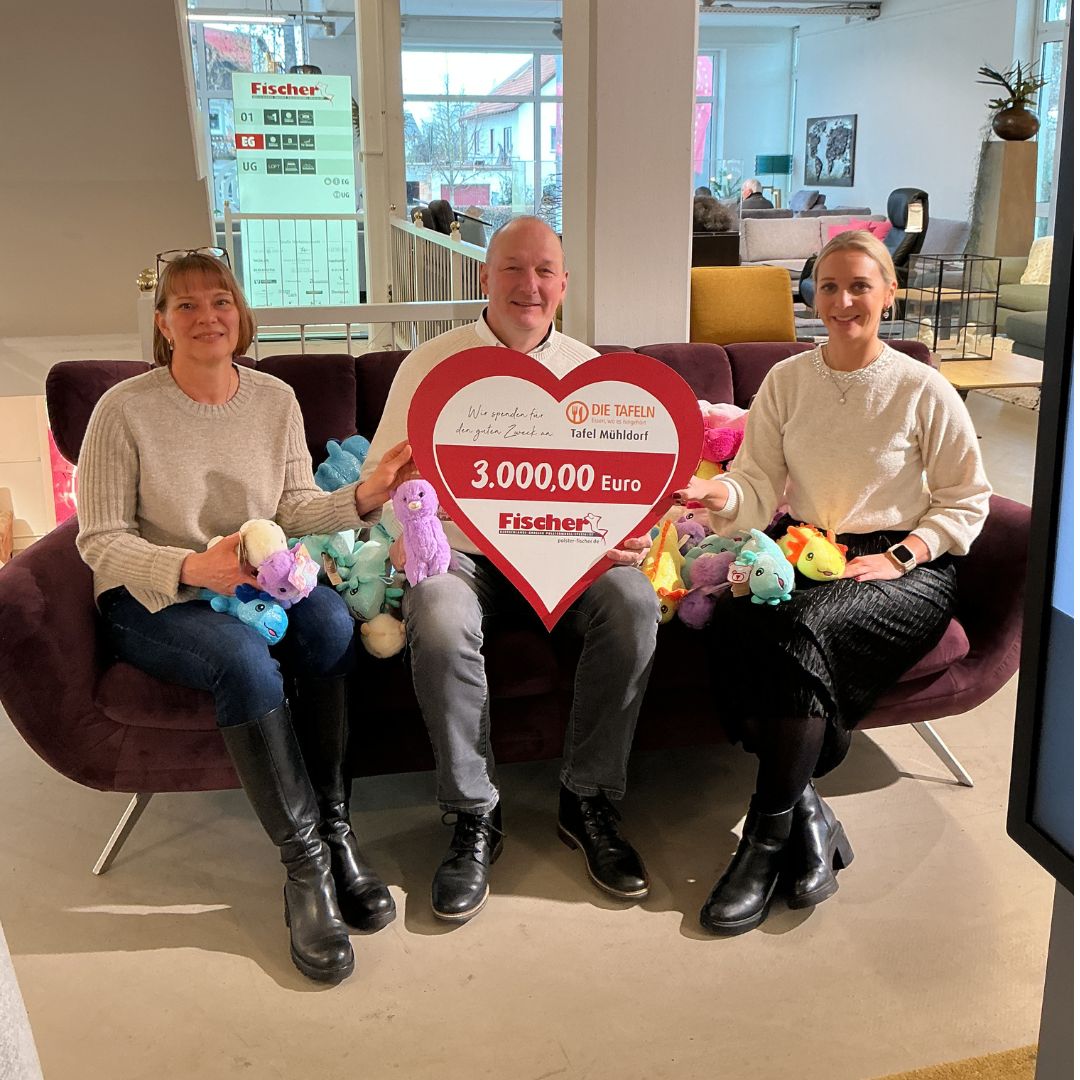 Spenden&uuml;bergabe von Polsterm&ouml;bel Fischer an die Tafel M&uuml;hldorf mit Spendenscheck &uuml;ber 3.000 Euro und Kuscheltieren im M&ouml;belhaus