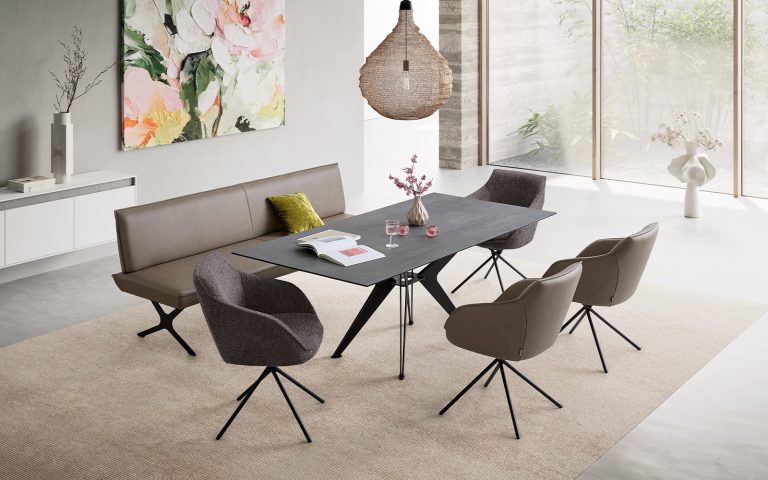 Moderner Essbereich mit schwarzem Esstisch, Polsterbank und vier Designerstühlen in hellem Wohnambiente